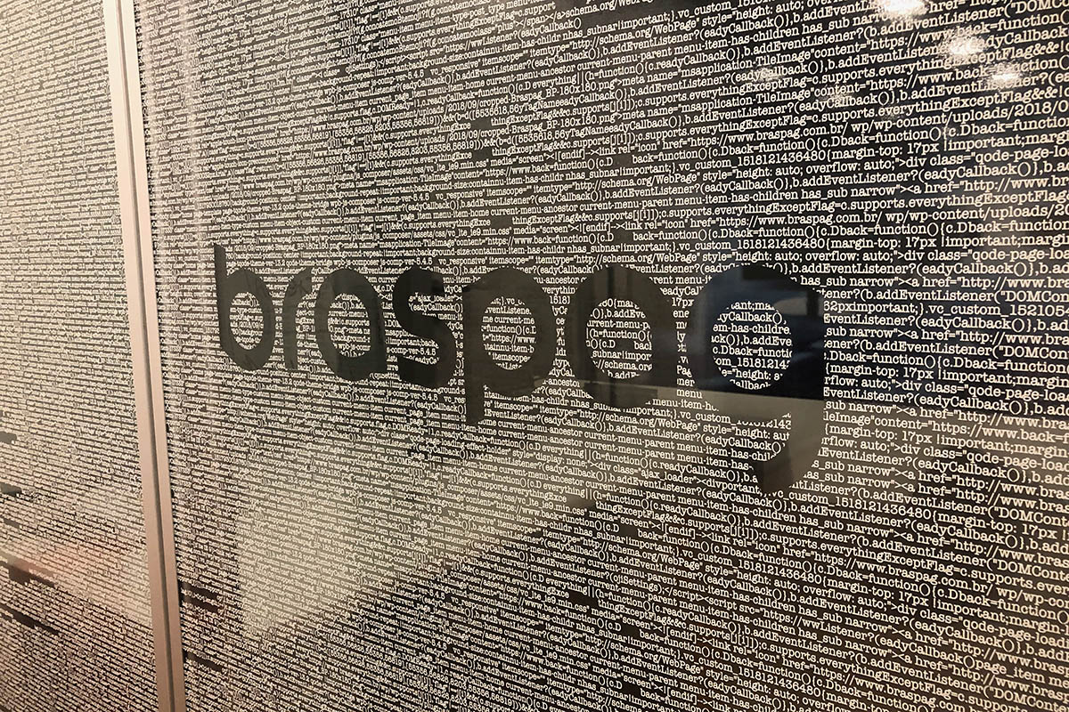 Divisória de vidro com o logotipo da Braspag e um padrão de texto