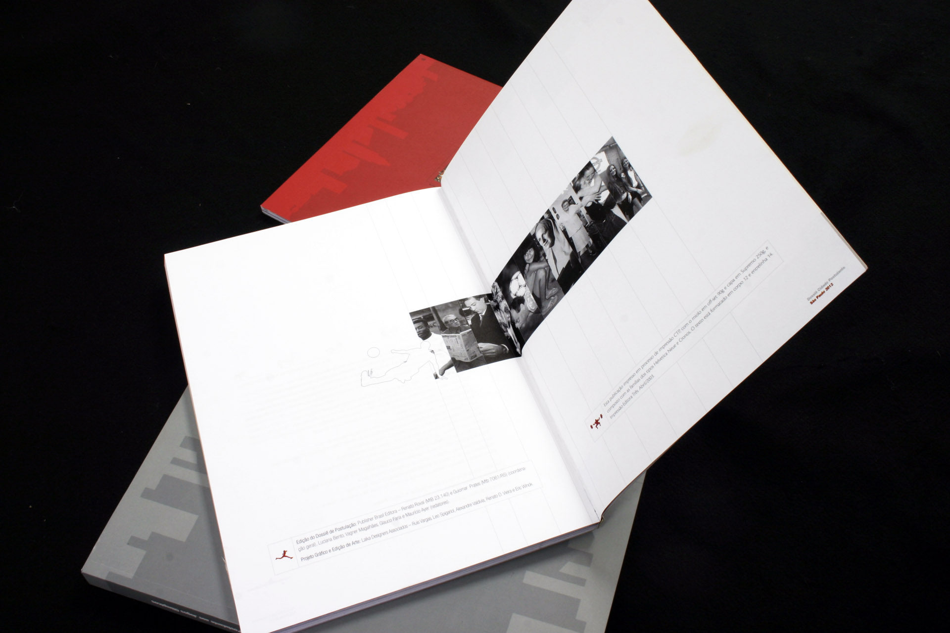 Volume do dossiê olímpico aberto, com uma faixa de fotos em preto e branco atravessando a página dupla