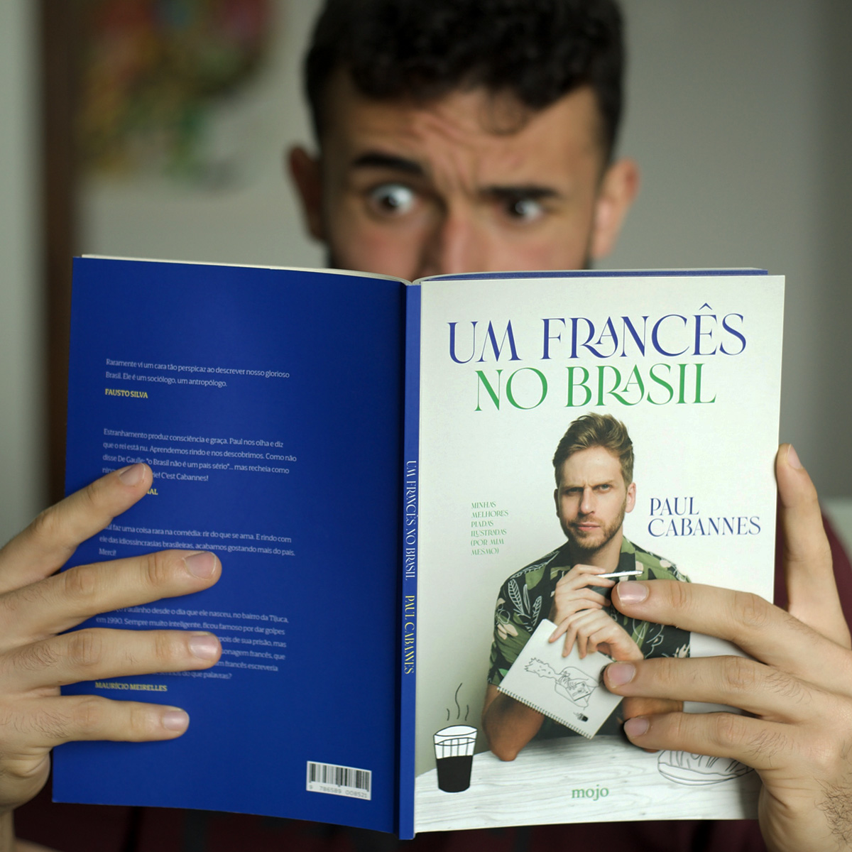 Pessoa lendo Um francês no Brasil, com a capa, a lombada e a contracapa à vista