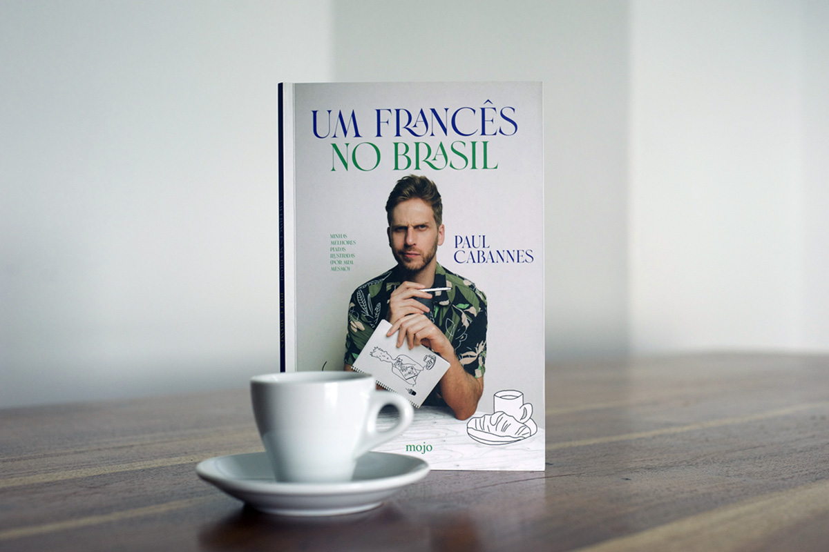 Capa do livro Um francês no Brasil, de Paul Cabannes, com o retrato do autor, sobre uma mesa ao lado de uma xícara de café
